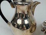 a silver tea pot and a silver teapot on a table