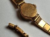 a watch that is laying on a table next to a bracelet