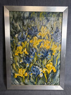 tableau représentant des fleurs jaunes et bleues dans un cadre argenté sur fond noir