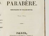 un livre ouvert posé sur une table à côté d'un mur blanc