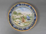 a plate with a painting of a man and a dog on it