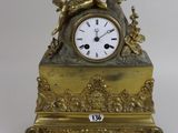 a gold clock sitting on top of a table