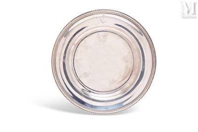une plaque ovale en argent, bordée de perles, sur fond blanc