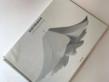 an image of a book on a white table with a bird on it
