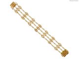 gros plan d'un bracelet en or sur fond blanc