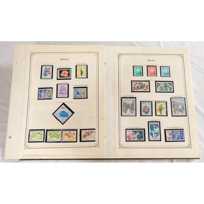 un livre ouvert, orné de timbres, posé sur une surface blanche