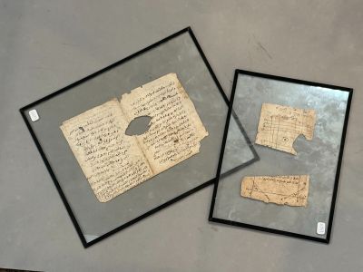 deux feuilles de papier encadrées et une feuille de papier posée sur une table
