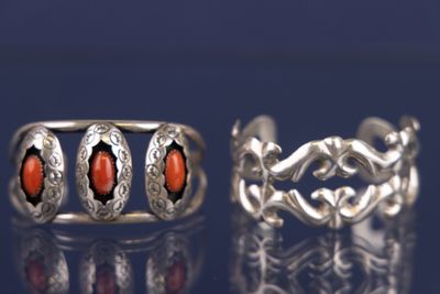 deux bagues en argent ornées de pierres rouges sur un fond bleu