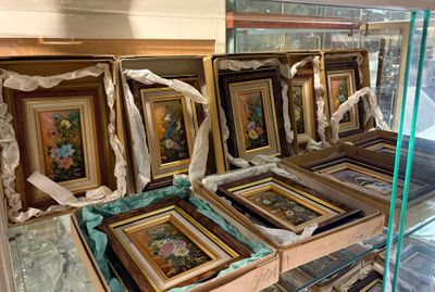 de nombreuses œuvres d'art encadrées exposées dans une vitrine