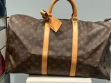 a brown and tan louis vuitton bag sitting on top of a white box