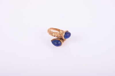 Gros plan sur une bague en or ornée de pierres bleues
