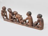 une figurine en bois représentant trois hommes assis sur un banc