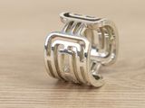 sterling silver ring with a stylized design on a wooden surface
