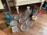 a lot of glass items on the floor next to a dresser