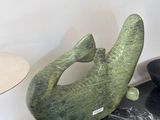 a green sculpture of a fish on a black table