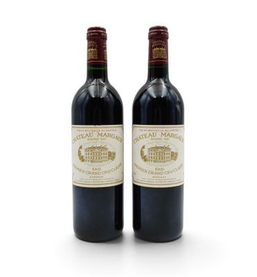two bottles of red wine sitting next to each other on a white surface