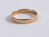 a close up of a gold ring on a white surface