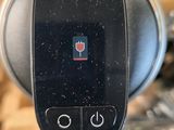 a close up of a button on the side of a coffee maker
