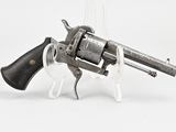 un vieux revolver avec un manche en bois sur fond blanc