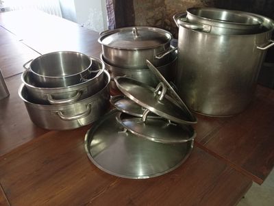 many pots and pans sitting on a wooden table