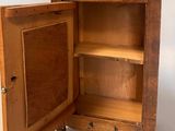 a wooden cabinet with a door open on a white background