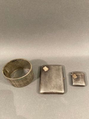 un briquet en argent et un étui à briquet posés sur une table