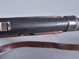an old gun with a leather strap on a white surface