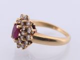a close up of a gold ring with a ruby stone