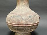 an old vase sitting on a table with a gray background