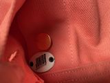 a button that is in the pocket of a pink shirt