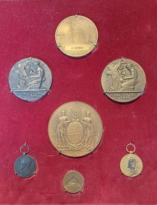 une photo montrant une collection de médailles dans une vitrine rouge