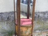une vitrine en verre sur laquelle est posé un coussin rouge