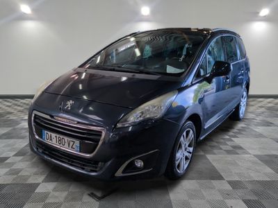 la petite voiture noire est garée dans le garage sur un sol en damier