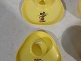 trois assiettes jaunes ornées de motifs représentant Mickey Mouse, posées sur une table