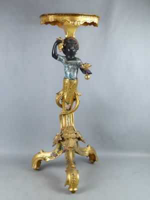un vase doré et noir posé sur un socle, orné d'un oiseau