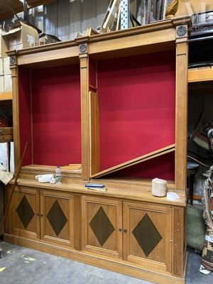 un grand meuble TV en bois avec un écran rouge derrière