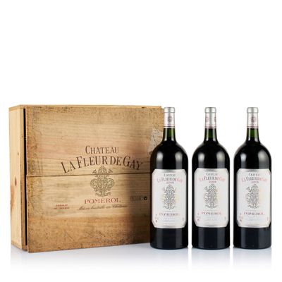 trois bouteilles de vin rouge devant une caisse en bois
