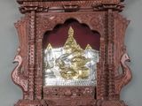 une image représentant une horloge en bois ornée d'un motif plaqué or