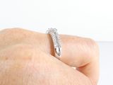 a person ' s hand holding a diamond ring on a white surface