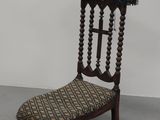 une chaise ancienne en bois avec une assise tressée et un repose-pieds