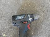 a cordless drill that is laying on the ground