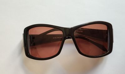 des lunettes de soleil noires aux verres roses sur un fond blanc