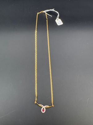 un collier en or orné d'une pierre rose et d'une chaîne en or