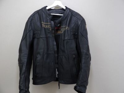 a black leather jacket hanging on a hanger on a wall