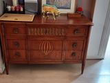 a dresser with a picture on top of it in a living room