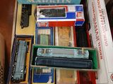 beaucoup de trains miniatures dans une boîte sur une table