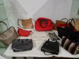 de nombreux sacs à main et sacs posés sur une table dans une pièce