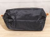 the small black bag is sitting on a wooden table