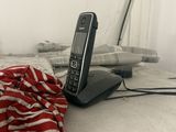a cell phone sitting on top of a bed with a red and white blanket