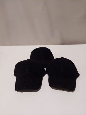trois chapeaux noirs posés sur une table blanche, sur fond blanc